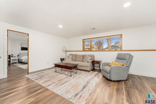 living room featuring visible vents, wood finished floors, baseboards, and recessed lighting