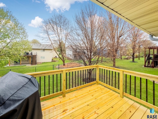 wooden deck with stairway and a lawn