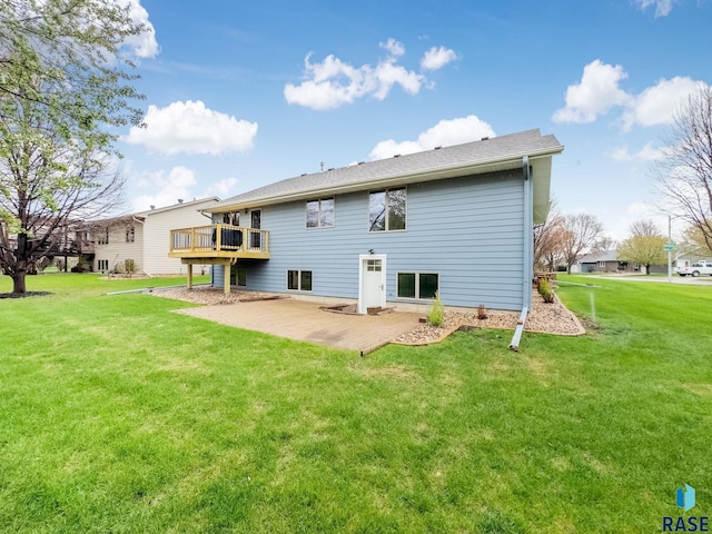 rear view of house with a patio area, a wooden deck, and a lawn