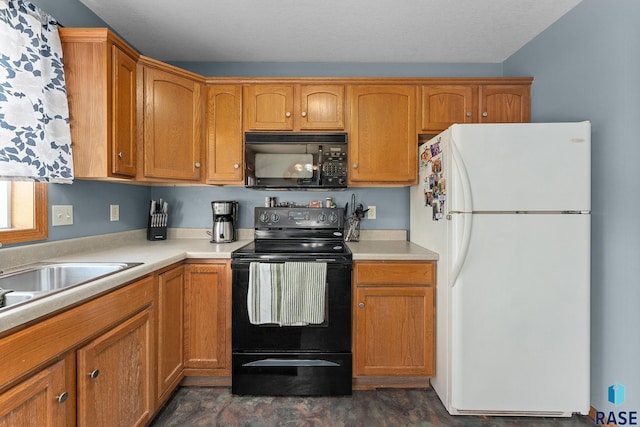 kitchen with brown cabinetry, black appliances, light countertops, and a sink