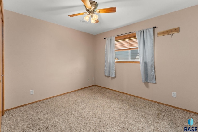 spare room with a ceiling fan, baseboards, visible vents, and carpet