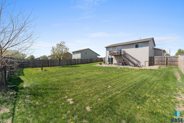 view of yard featuring a wooden deck, a fenced backyard, and stairs