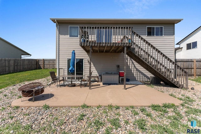 back of house with stairs, a patio area, a fire pit, and a fenced backyard