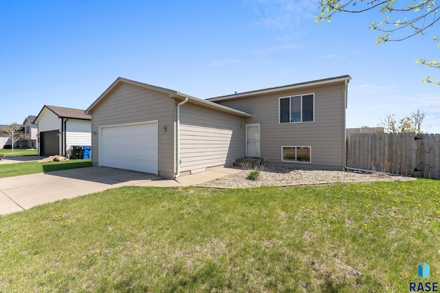 split level home featuring an attached garage, fence, and a front yard