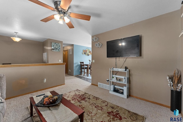 carpeted living area with ceiling fan, baseboards, and visible vents