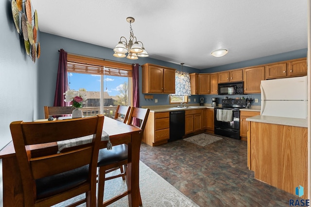 kitchen with hanging light fixtures, a sink, a chandelier, black appliances, and light countertops