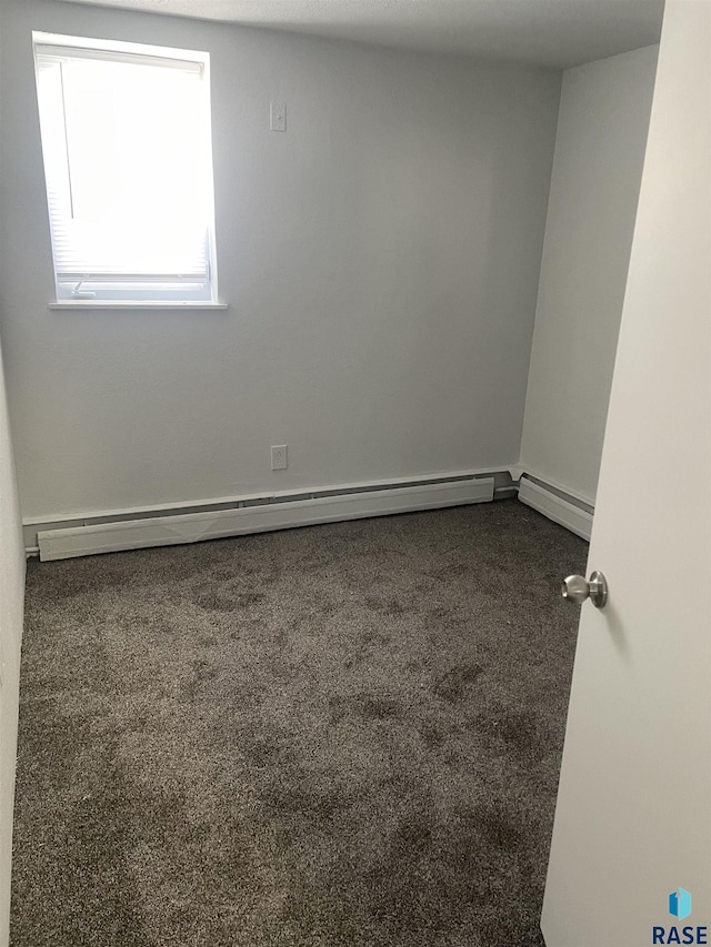 207 W 14th St, Sioux Falls, SD 57104 - spare room with a baseboard heating unit and dark carpet