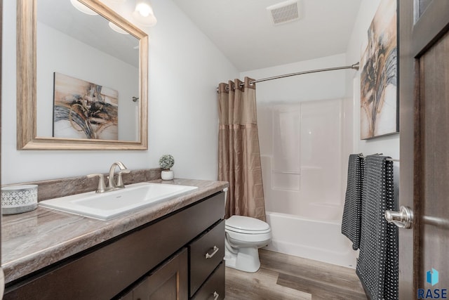bathroom with shower / tub combo, toilet, visible vents, vanity, and wood finished floors