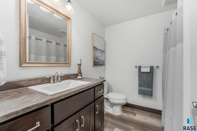 full bathroom featuring toilet, wood finished floors, visible vents, baseboards, and vanity