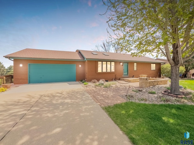 ranch-style house featuring concrete driveway and a garage