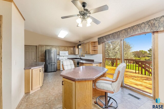 kitchen with a center island, white appliances, visible vents, a sink, and open shelves