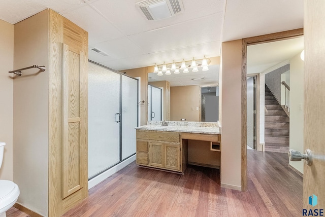 bathroom with toilet, visible vents, wood finished floors, and a shower stall