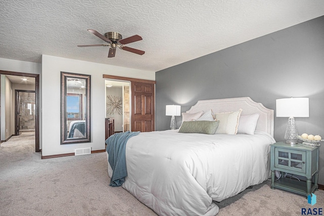 6601 Lenola Hts, Wentworth, SD 57075 - carpeted bedroom with a ceiling fan, a textured ceiling, baseboards, ensuite bath, and visible vents