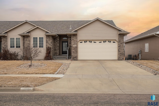 7408 W 58th St, Sioux Falls, SD 57106 - single story home with roof with shingles, concrete driveway, an attached garage, and brick siding