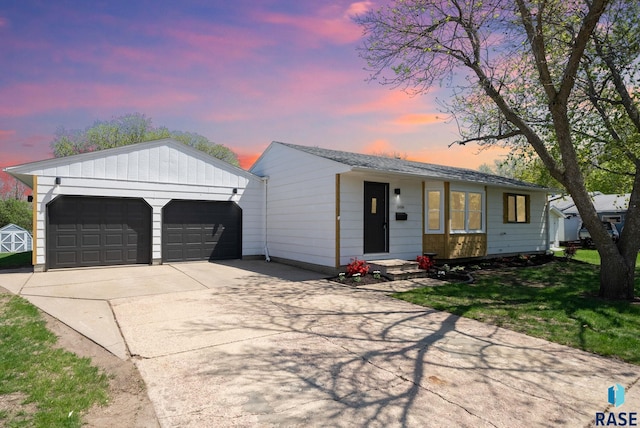 ranch-style house featuring a garage, an outbuilding, and driveway