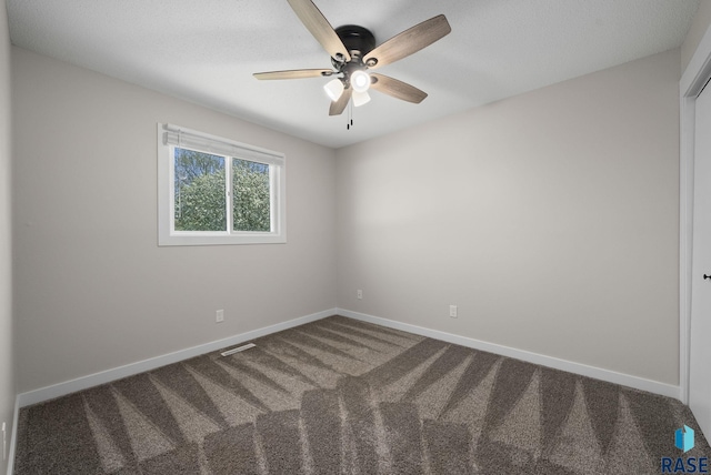 carpeted empty room featuring visible vents, baseboards, and ceiling fan