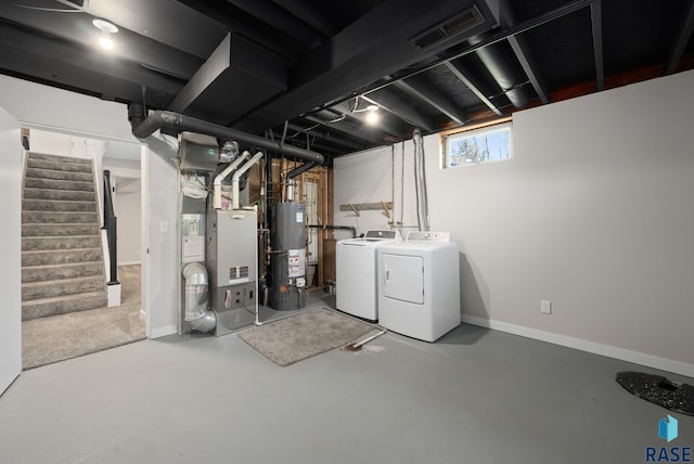 basement with stairs, water heater, visible vents, washer and dryer, and baseboards