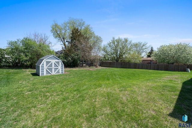 view of yard with an outbuilding, a shed, and fence