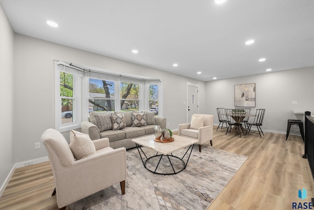 living room with light wood-style flooring, baseboards, and recessed lighting