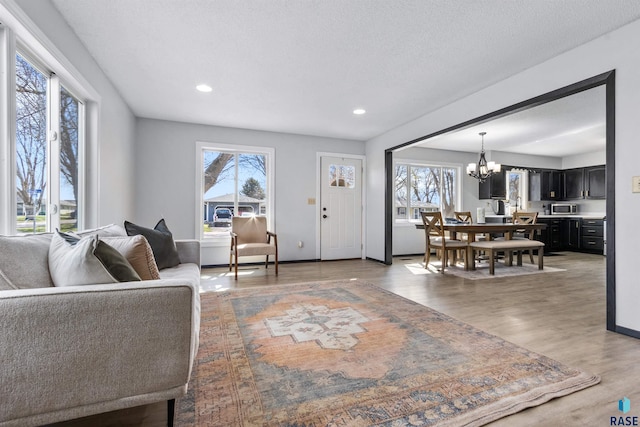 1120 Blaine St, Larchwood, IA 51241 - living room featuring an inviting chandelier, light wood-style flooring, baseboards, and recessed lighting