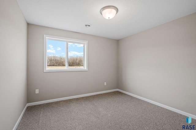 carpeted spare room with baseboards