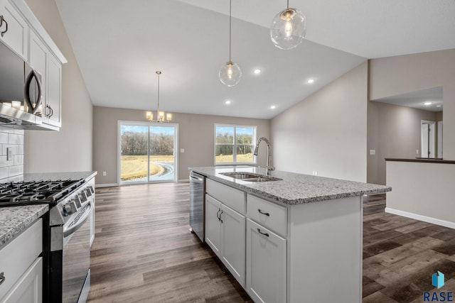kitchen featuring a sink, stainless steel appliances, dark wood finished floors, vaulted ceiling, and light stone countertops