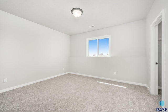 unfurnished bedroom with carpet floors, baseboards, and visible vents