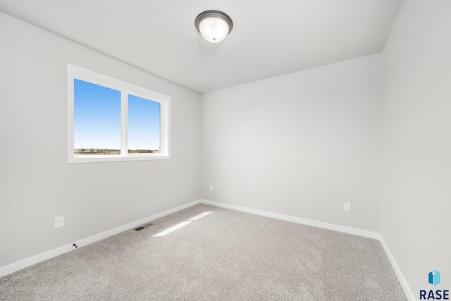 empty room featuring baseboards, visible vents, and carpet floors