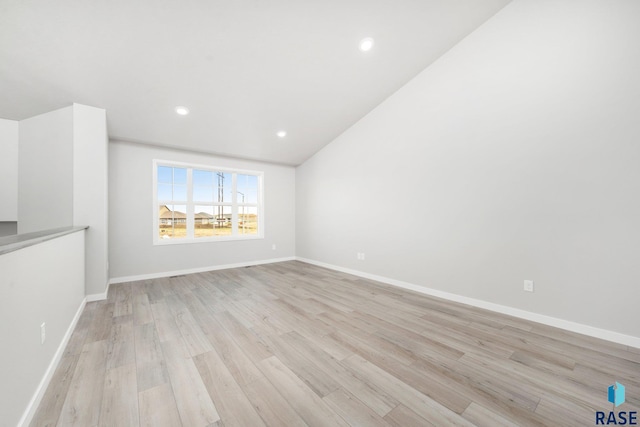 unfurnished living room featuring vaulted ceiling, light wood-style flooring, baseboards, and recessed lighting