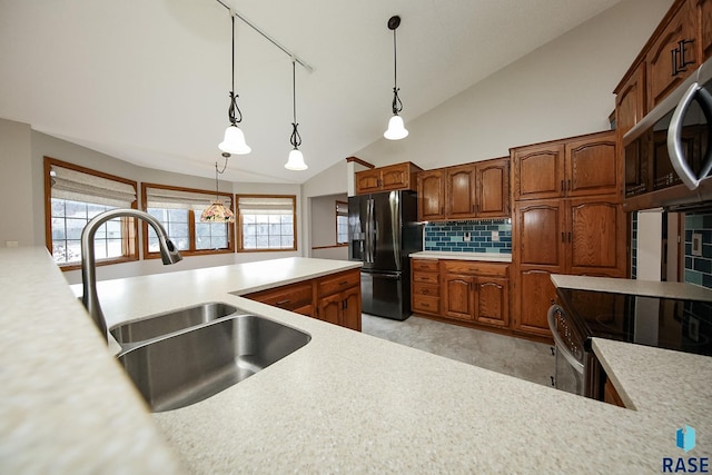 kitchen with light countertops, stainless steel appliances, decorative backsplash, and a sink