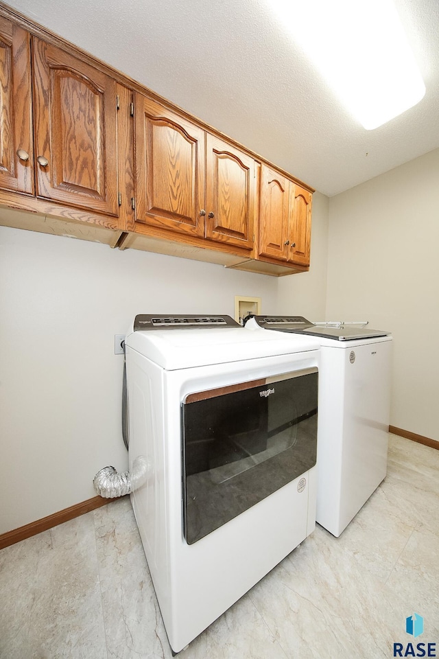 laundry area with cabinet space, independent washer and dryer, and baseboards