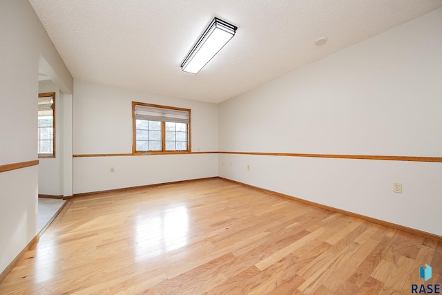 unfurnished room with baseboards and light wood-style flooring