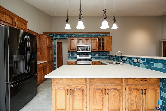 kitchen with stainless steel appliances, a sink, a peninsula, backsplash, and light countertops