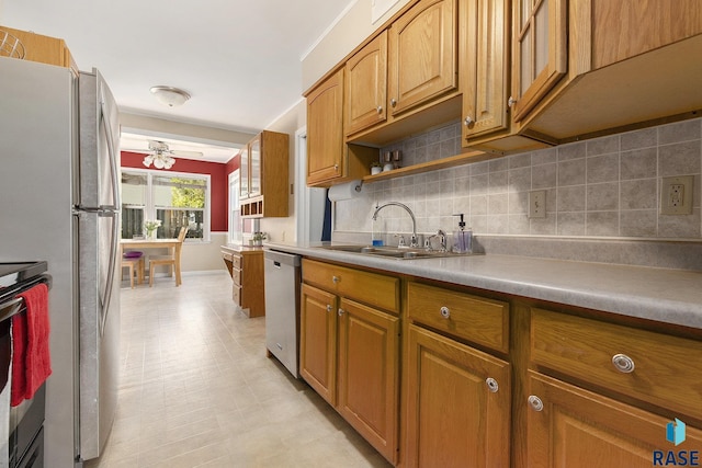 kitchen with a sink, light floors, tasteful backsplash, and appliances with stainless steel finishes
