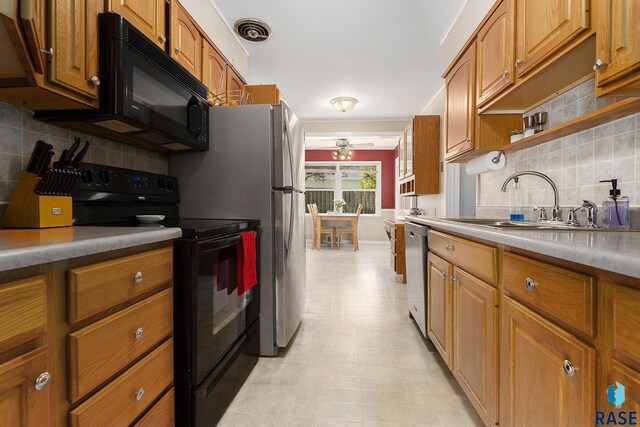kitchen featuring a ceiling fan, brown cabinetry, a sink, black appliances, and tasteful backsplash