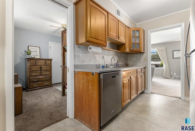 kitchen with stainless steel dishwasher, glass insert cabinets, visible vents, a sink, and light carpet