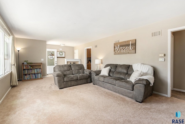 living area with baseboards, carpet flooring, and visible vents