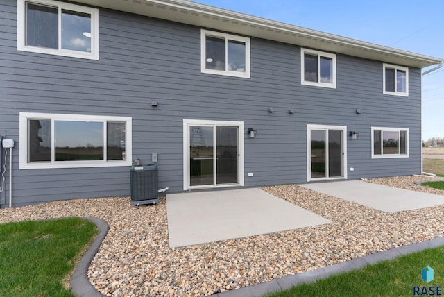 rear view of property with central air condition unit and a patio area