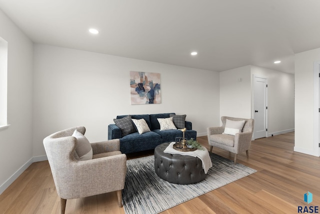 living area with light wood-type flooring, baseboards, and recessed lighting