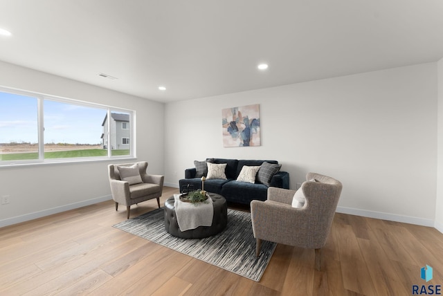 living room featuring baseboards, recessed lighting, light wood-style floors, and visible vents
