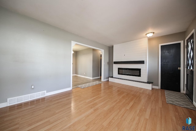 420 S Mary Ave, Tea, SD 57064 - unfurnished living room featuring wood finished floors, baseboards, and a large fireplace