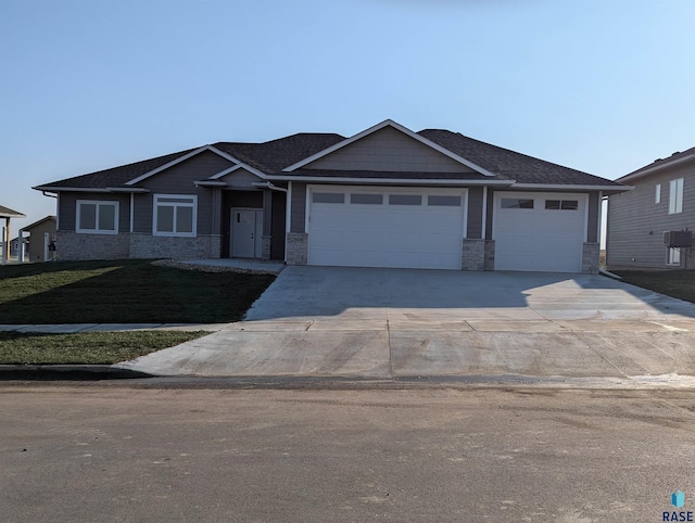 2604 S Galena Ave, Sioux Falls, SD 57110 - view of front facade with a garage, concrete driveway, stone siding, a shingled roof, and a front lawn