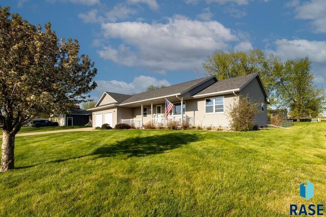 single story home featuring a garage, a front yard, a porch, and driveway