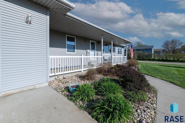 property entrance featuring a yard and a porch