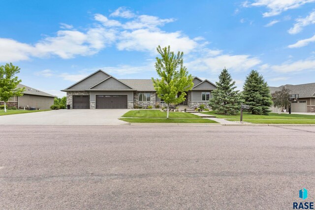 2708 W Bitterroot St, Sioux Falls, SD 57108 - view of front of property with an attached garage, stone siding, driveway, and a front lawn