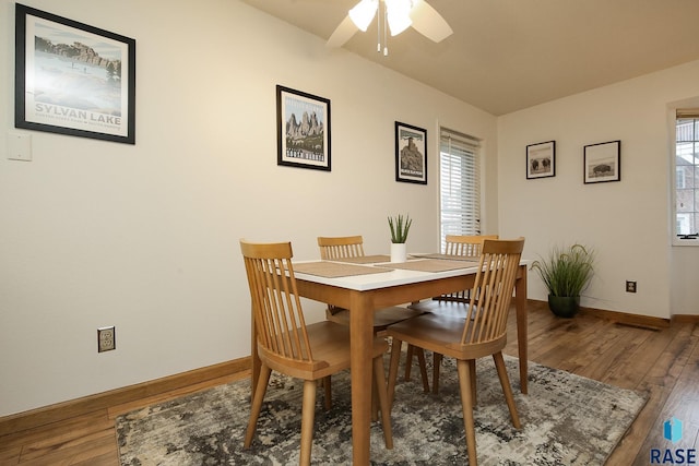 dining space featuring healthy amount of natural light, a ceiling fan, wood finished floors, and baseboards