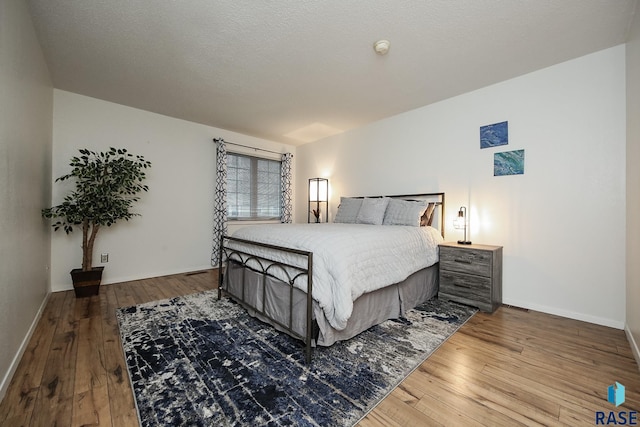 bedroom with hardwood / wood-style floors and baseboards