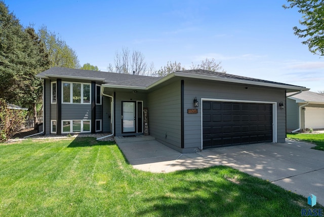 view of front of house featuring an attached garage, driveway, and a front lawn