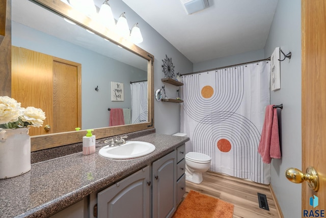 full bath with wood finished floors, toilet, and vanity