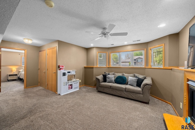 carpeted living room with baseboards, a textured ceiling, a ceiling fan, and recessed lighting
